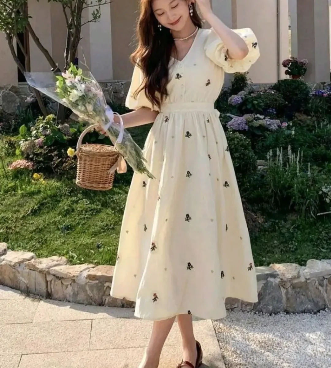 Cream floral print midi dress with puff sleeves worn by a woman outdoors