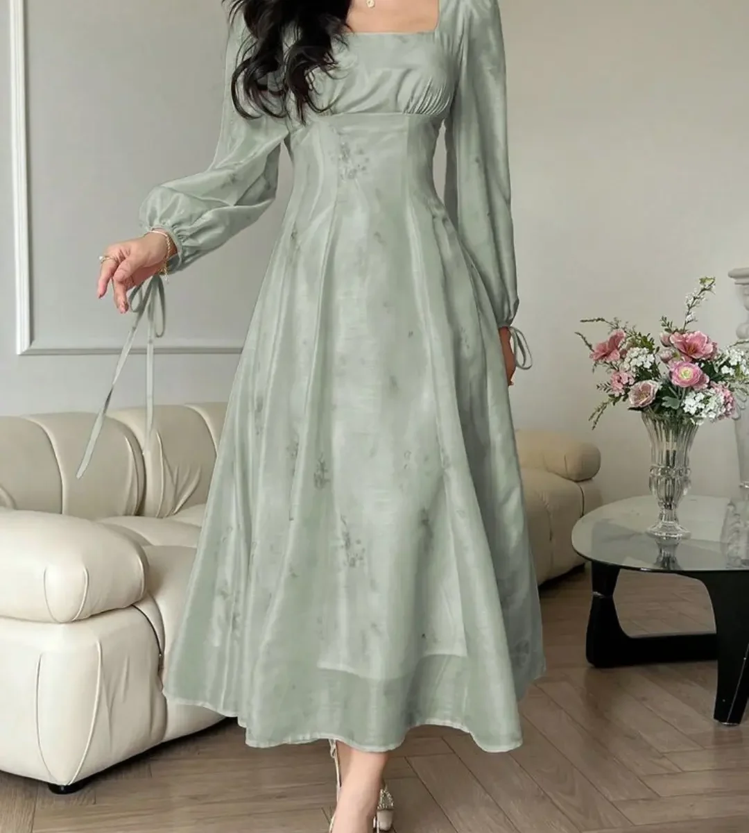 Sage green long-sleeve chiffon midi dress worn by a woman indoors